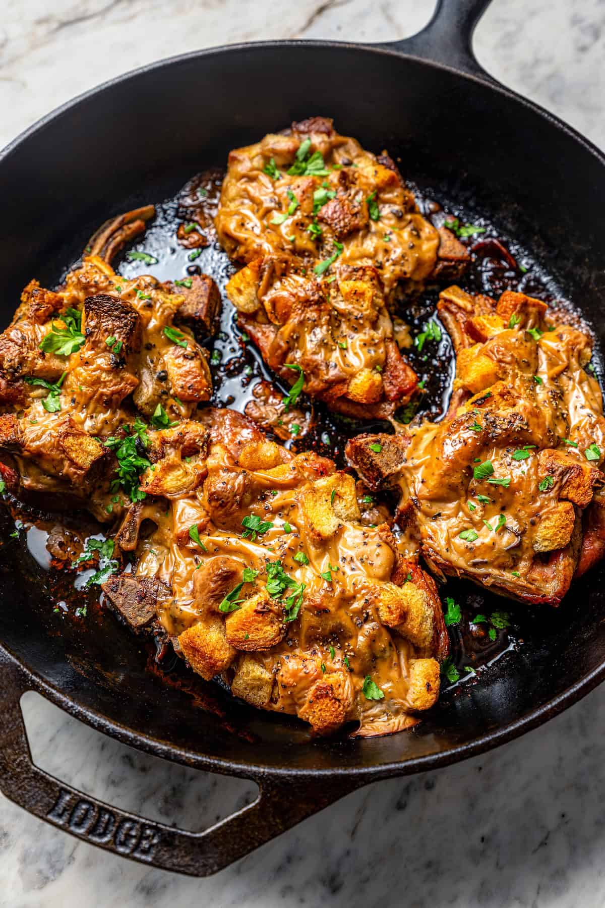 Juicy pork chops with stuffing and mushroom sauce in the skillet.