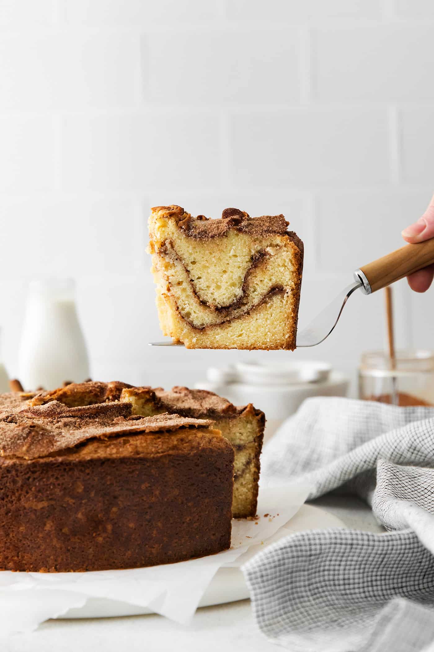 A spatula serving a slice of sour cream coffee cake with cinnamon ripple