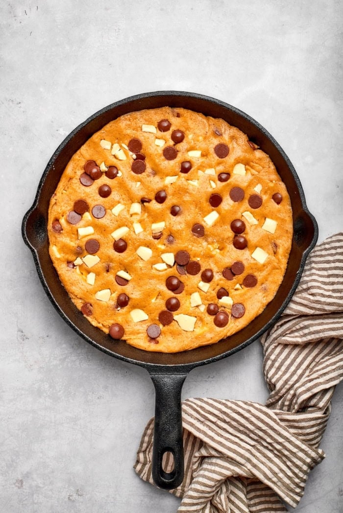 Nutty brown butter, flaky sea salt and fluffy buttercream make this chewy chocolate chip skillet cookie worthy of a celebration. So easy too! Brown butter chocolate chip skillet cookie in cast iron skillet.