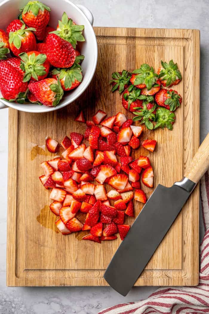 These homemade Strawberry Scones are buttery and golden, and studded with fresh berries. A drizzle of vanilla glaze is the perfect finish! Overhead view of strawberries on cutting board