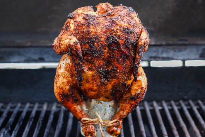This easy Beer Can Chicken Recipe guarantees moist meat and crispy, flavorful skin. It’s our go-to recipe for a grilled whole chicken! Cooked beer can chicken standing on can set on grill