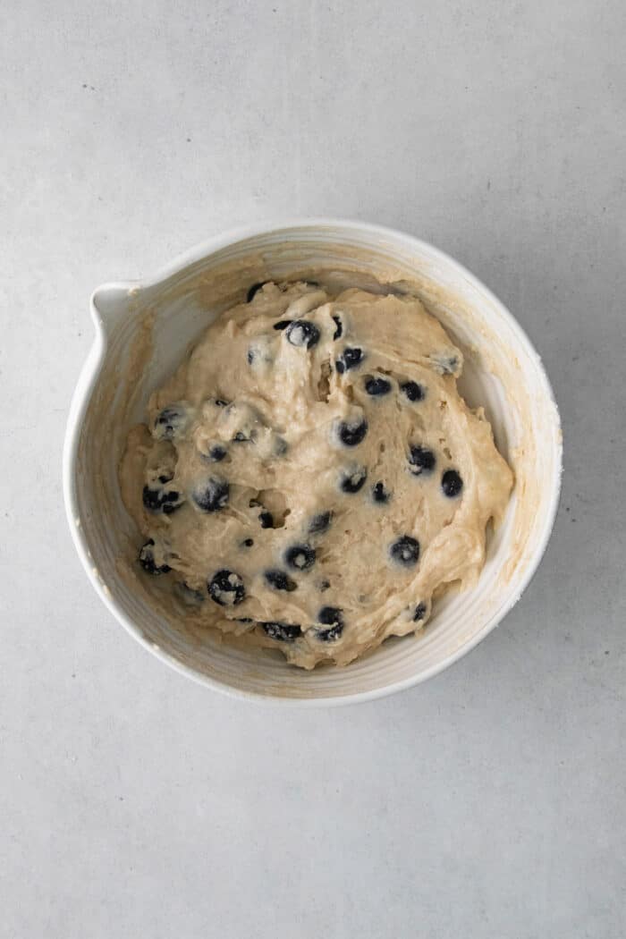 Soft, fluffy, and filled with blueberries, this family recipe makes a batch of the best blueberry muffins topped with a buttery streusel. Blueberry muffin batter in a mixing dish