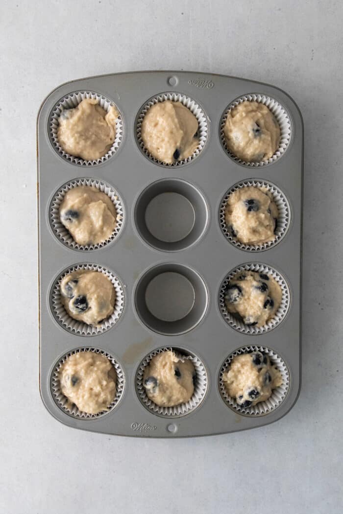 Soft, fluffy, and filled with blueberries, this family recipe makes a batch of the best blueberry muffins topped with a buttery streusel. Blueberry muffin batter in a muffin tin
