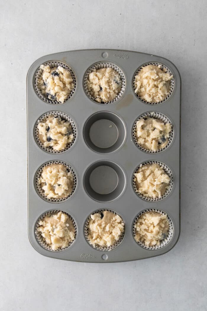 Soft, fluffy, and filled with blueberries, this family recipe makes a batch of the best blueberry muffins topped with a buttery streusel. Blueberry muffin batter topped with sugar crumble topping