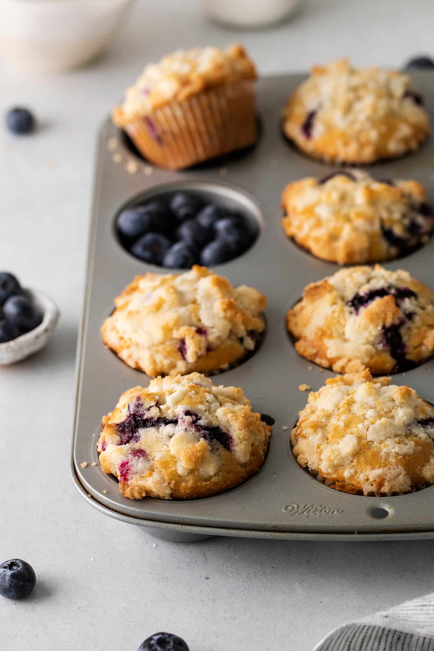 Soft, fluffy, and filled with blueberries, this family recipe makes a batch of the best blueberry muffins topped with a buttery streusel. Blueberry muffins in a muffin tin