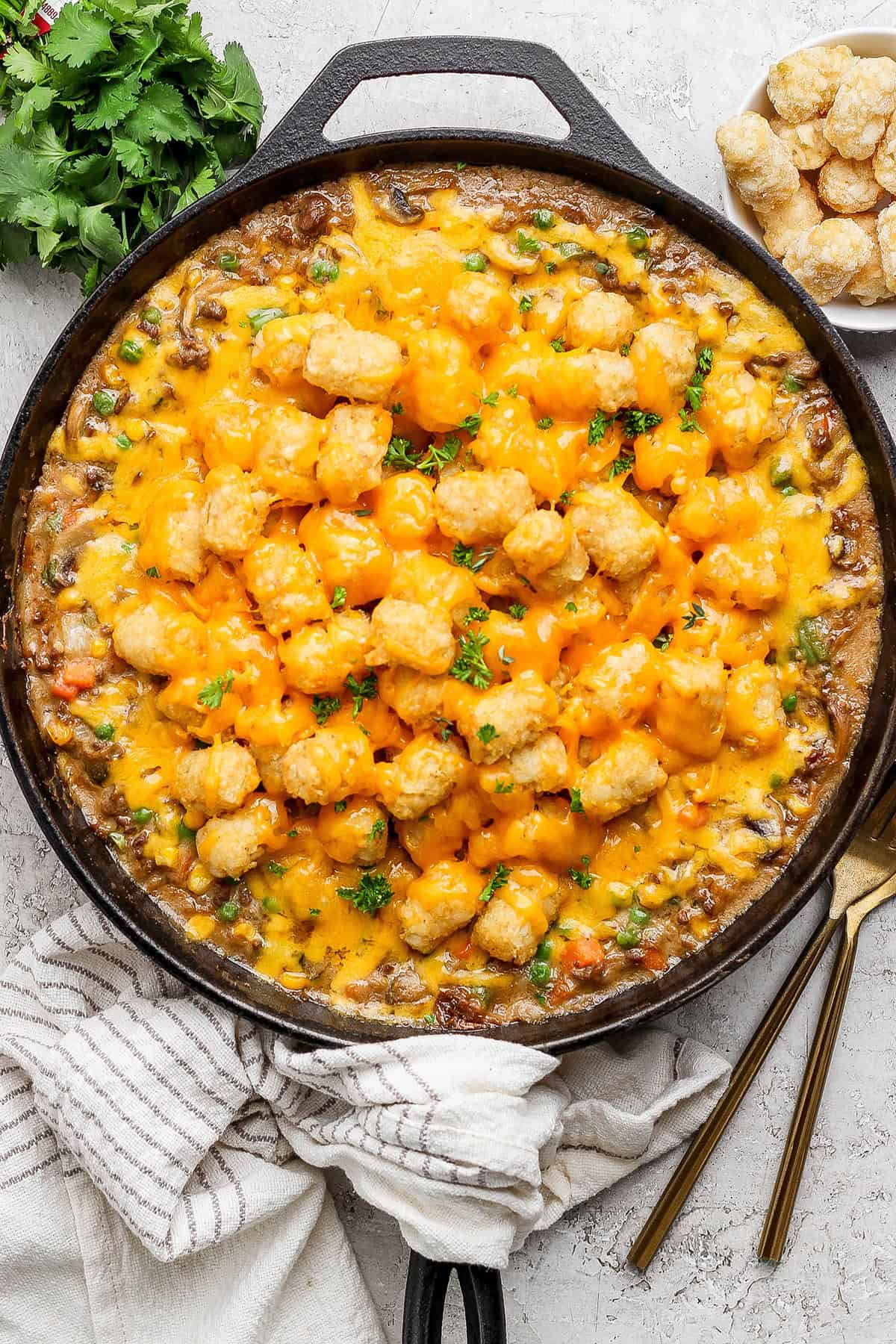 My easy made-from-scratch Tater Tot Hotdish is classic Minnesota comfort food — but fear not, I also share a canned soup version too! Overhead view of tater tot hotdish in skillet