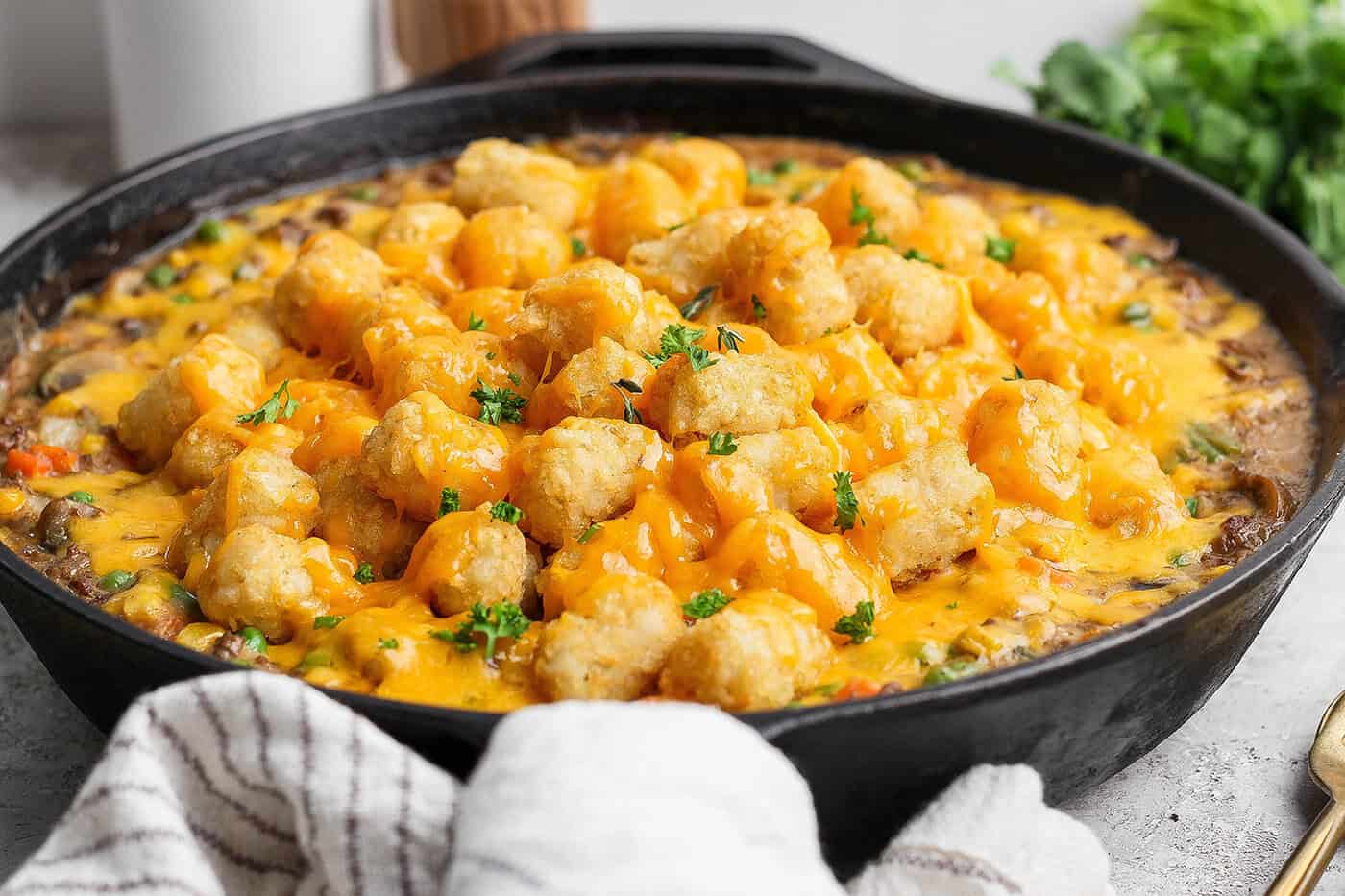 My easy made-from-scratch Tater Tot Hotdish is classic Minnesota comfort food — but fear not, I also share a canned soup version too! Tater tot hot dish in cast iron skillet