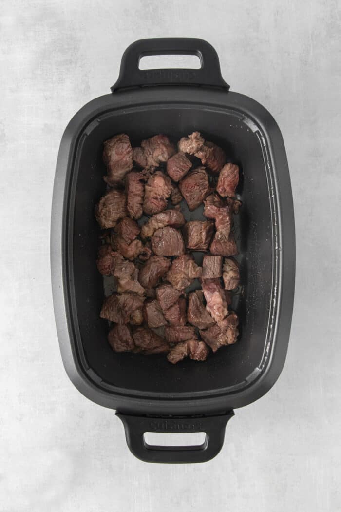 Slow Cooker Hungarian Goulash loaded with chunks of tender, melt-in-your-mouth beef and vegetables. Authentic, easy comfort food at its best! Pieces of seared chuck roast in a slow cooker
