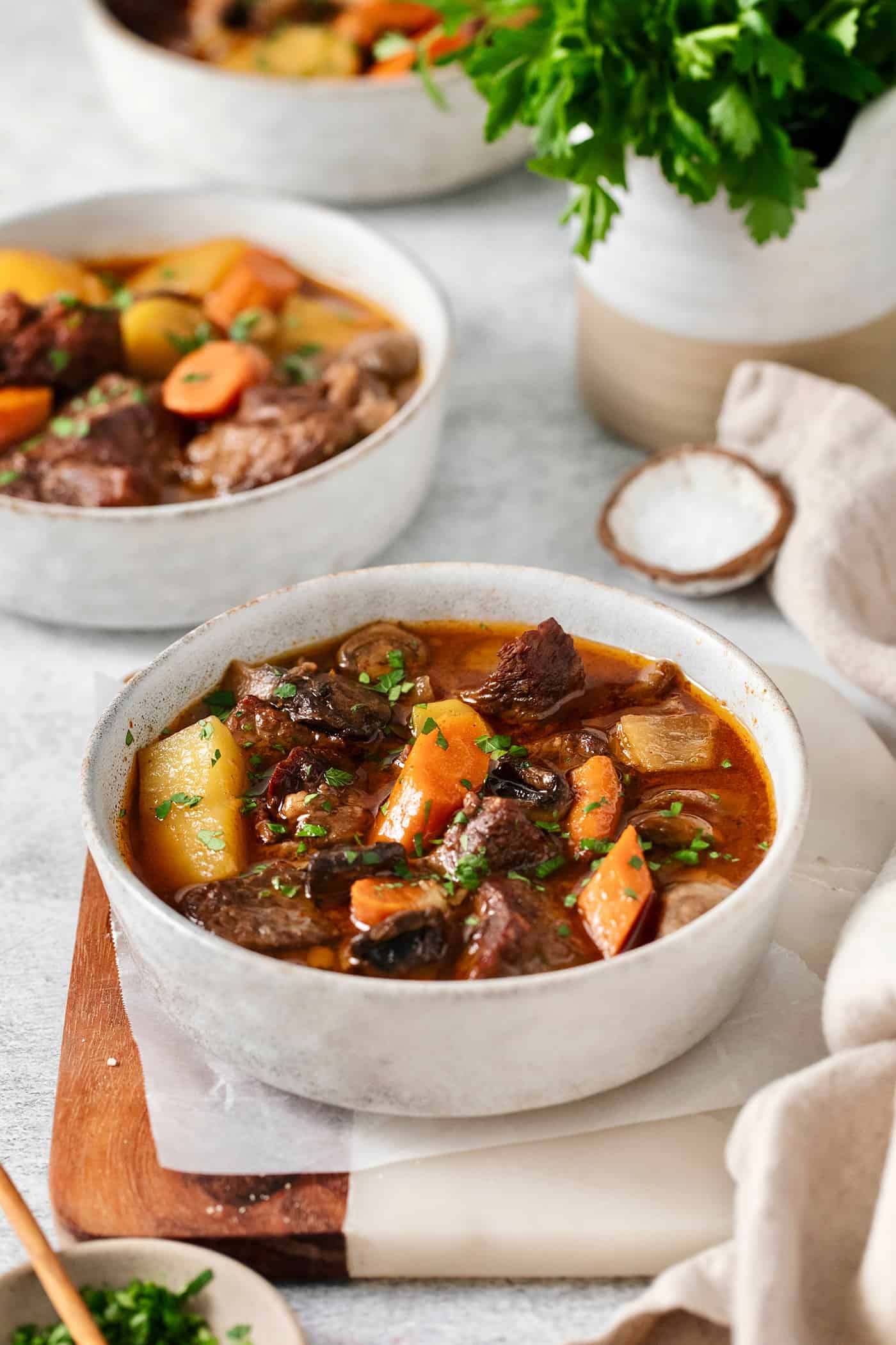 Slow Cooker Hungarian Goulash loaded with chunks of tender, melt-in-your-mouth beef and vegetables. Authentic, easy comfort food at its best! Angled view of bowls of authentic Hungarian goulash