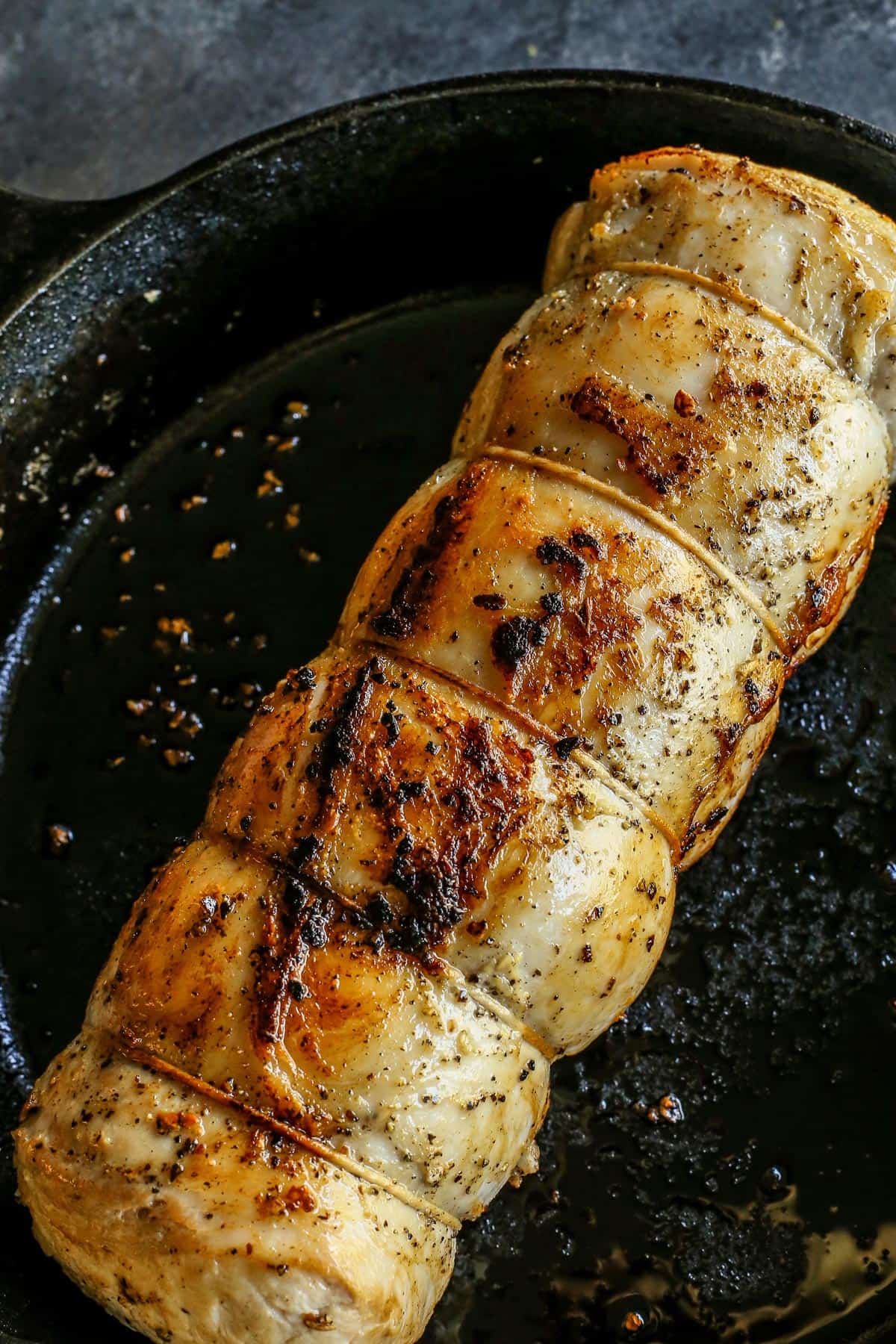 This pork loin roast recipe is juicy and tender, slathered with a savory mustard mixture and oven-roasted for a satisfying, easy pork dinner. Seared pork loin in a skillet.