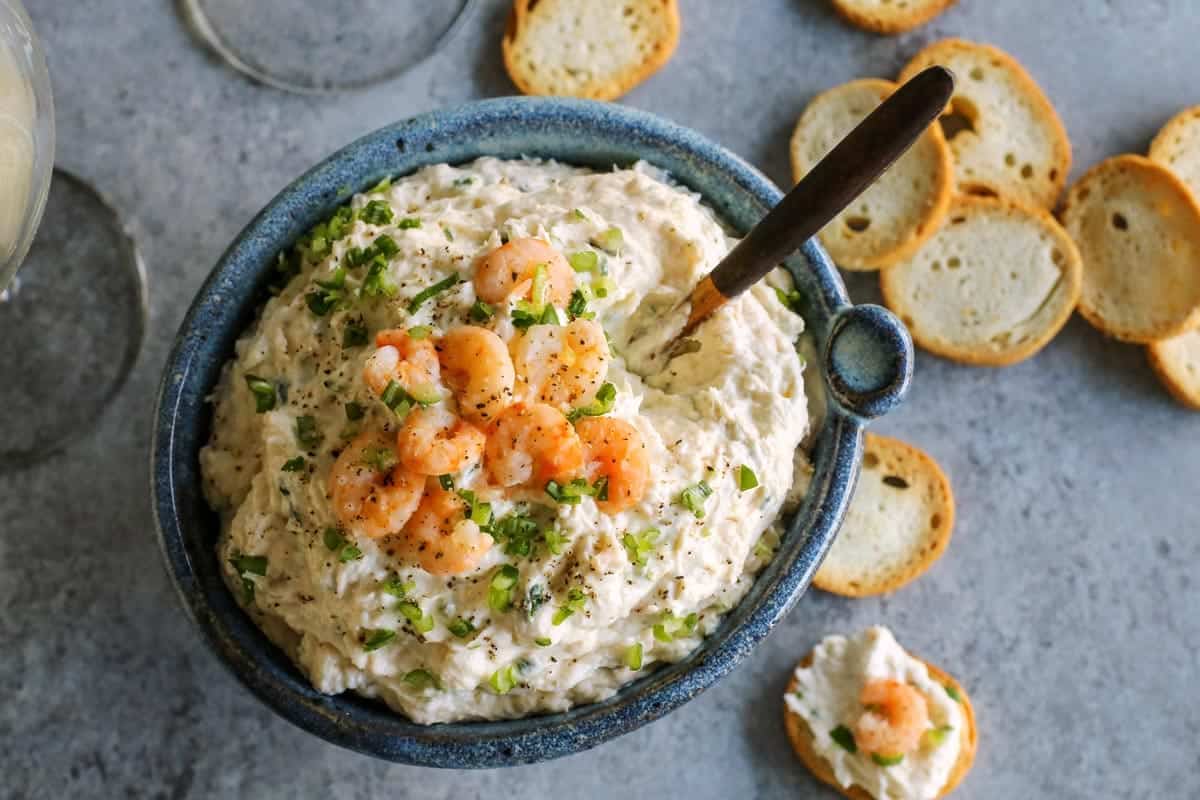 This shrimp dip recipe is an easy appetizer, made with just a few ingredients. It's thick and creamy, and full of tender, juicy shrimp! Blue pottery bowl of shrimp dip.