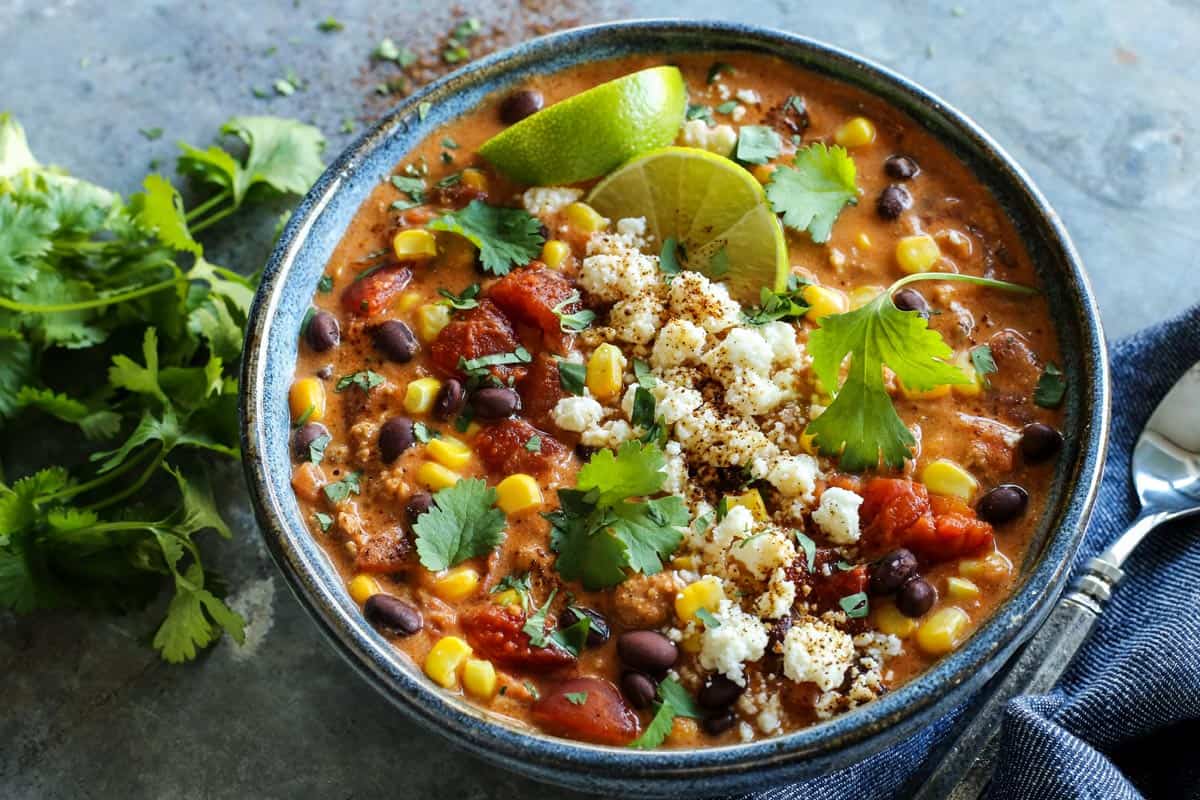 Creamy Enchilada Chili is brimming with tasty bites. In every spoonful, you'll savor the flavors of enchiladas...without tortillas! chili in a blue pottery bowl