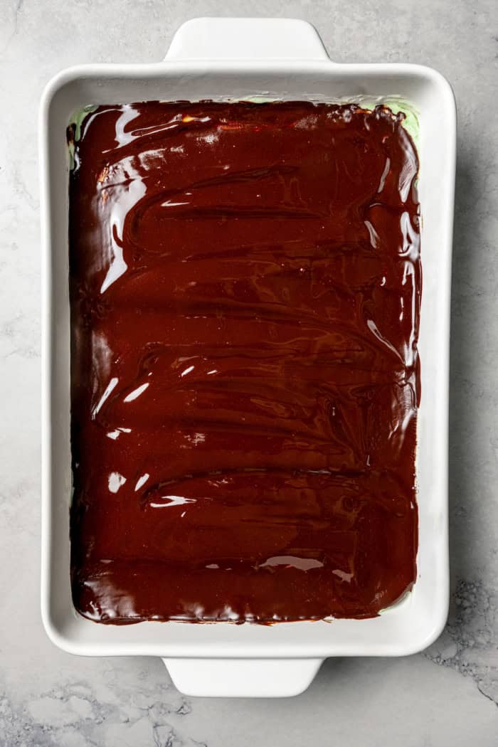 Overhead view of glaze spread onto pan of brownies