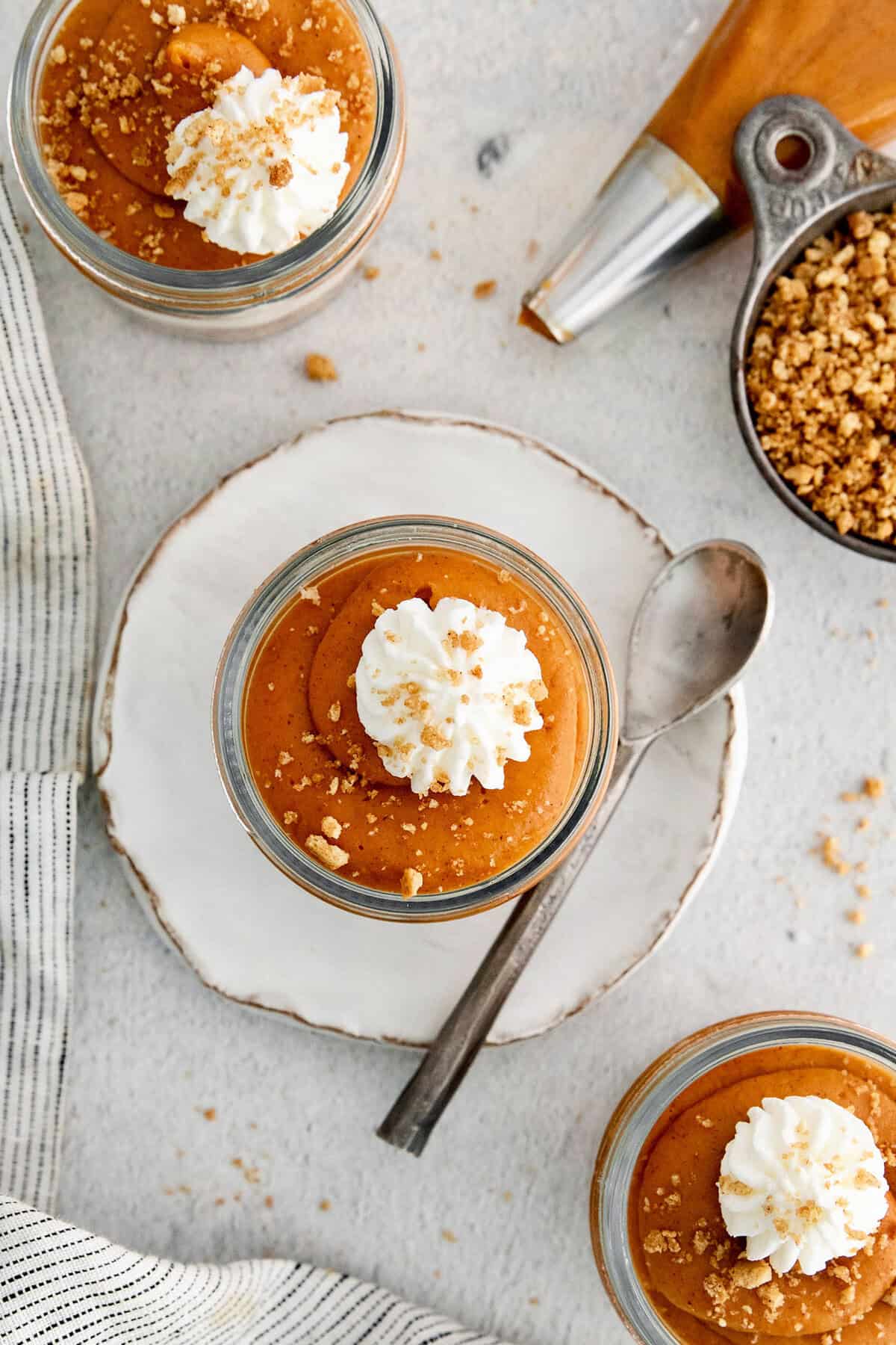 Overhead photo of creamy no-bake pumpkin pie in a jar with whipped cream on top.