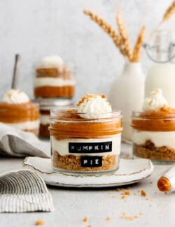 Layered pumpkin pie in a jar with whipped cream and chocolate shavings on top.