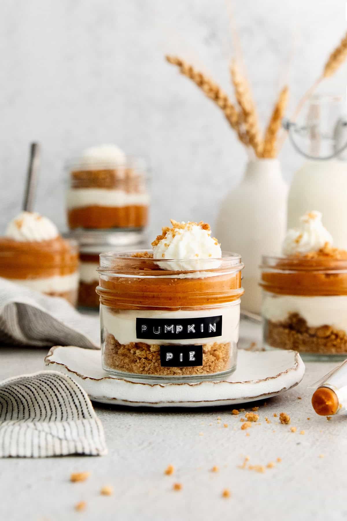 Layered pumpkin pie in a jar with whipped cream and chocolate shavings on top.