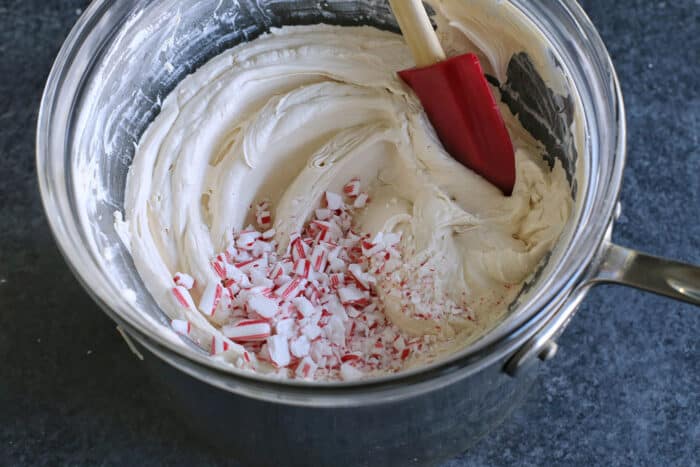 Creamy, minty peppermint bark is easy to make for the holidays with only 3 ingredients! This Christmas candy bark makes a great edible gift. Crushed candy canes being mixed into melted chocolate