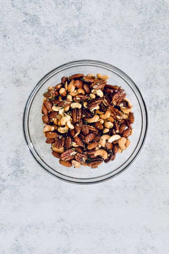 This homemade, baked spiced nuts recipe with herb-infused olive oil, cumin, spicy cayenne, and sugar is an easy holiday appetizer. Stir everything or toss gently.