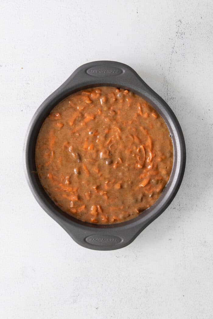 This classic carrot cake recipe is moist, perfectly spiced, and baked in a single layer, topped with creamy homemade cream cheese frosting. Carrot cake batter in a silver cake pan