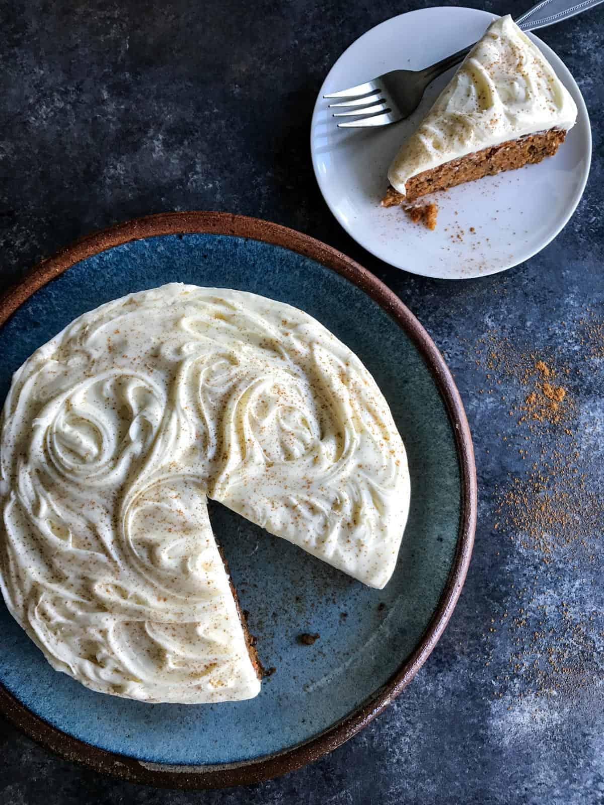 This classic carrot cake recipe is moist, perfectly spiced, and baked in a single layer, topped with creamy homemade cream cheese frosting. Carrot Cake with a slice taken out on a separate plate