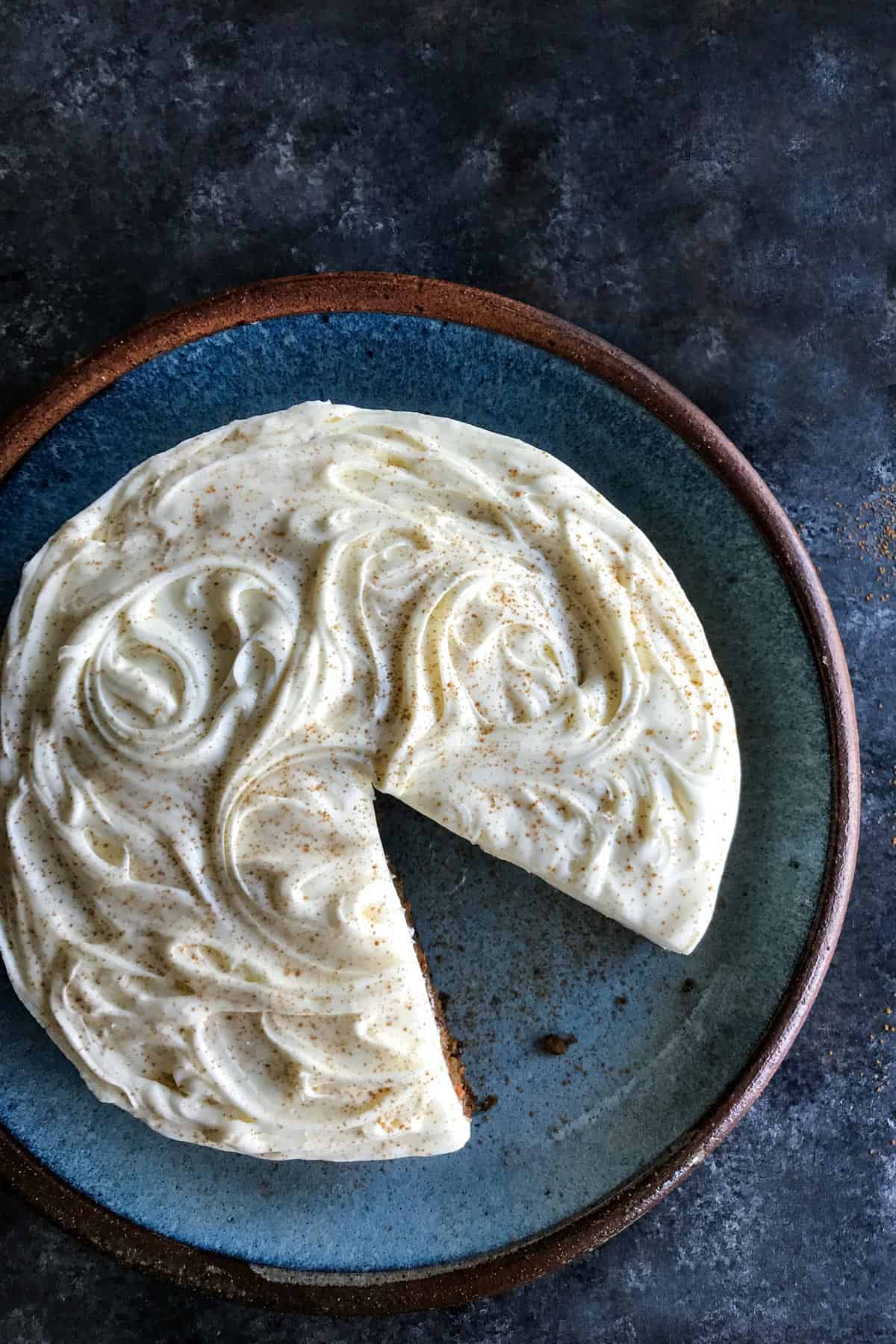 This classic carrot cake recipe is moist, perfectly spiced, and baked in a single layer, topped with creamy homemade cream cheese frosting. Overhead view of a carrot cake with a slice missing