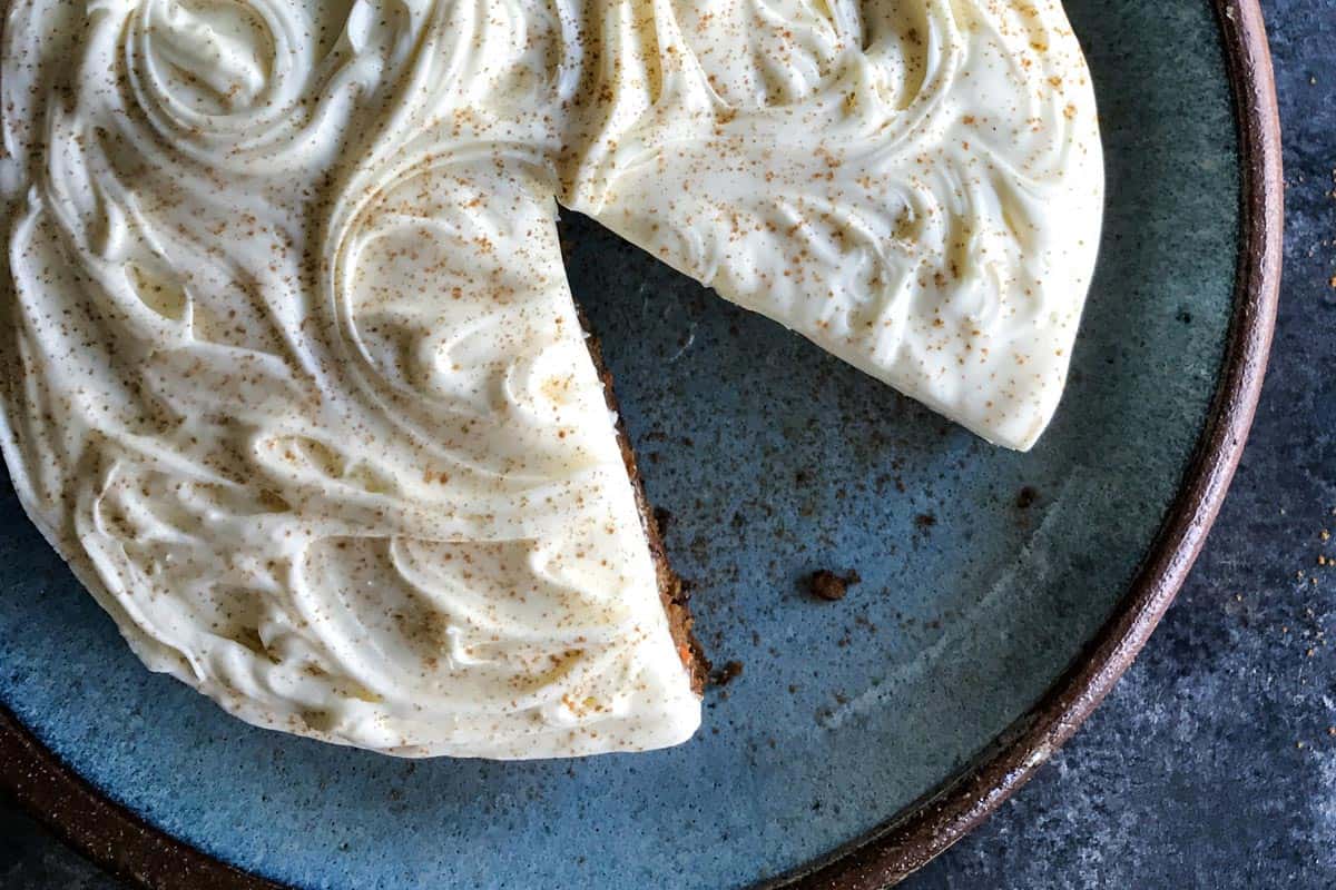 This classic carrot cake recipe is moist, perfectly spiced, and baked in a single layer, topped with creamy homemade cream cheese frosting. Close-up view of carrot cake with a slice missing