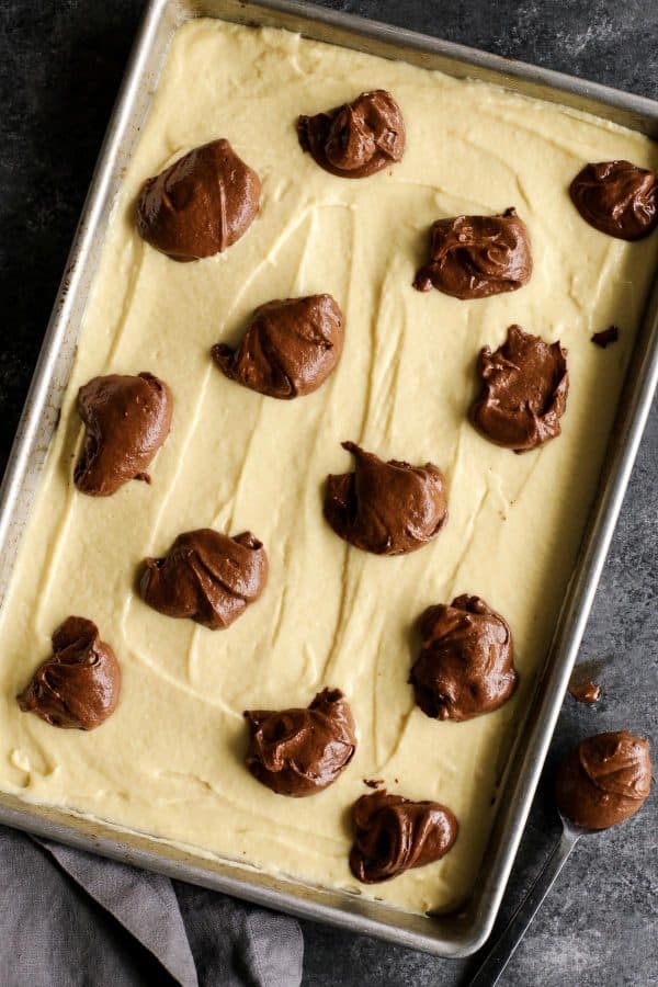 This Easy Marble Cake Recipe features a moist chocolate and vanilla sheet cake slathered with a rich & creamy chocolate buttercream frosting. marble cake being assembled before baking