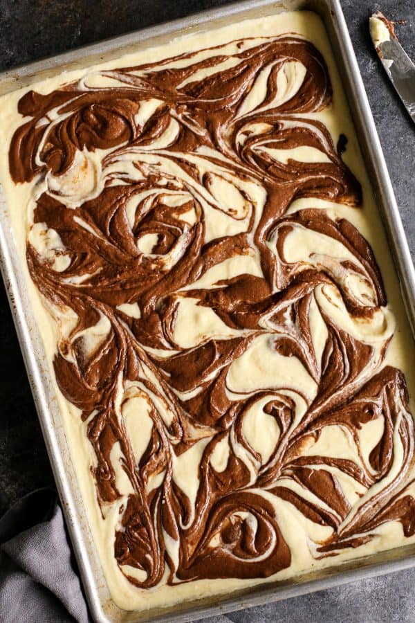 This Easy Marble Cake Recipe features a moist chocolate and vanilla sheet cake slathered with a rich & creamy chocolate buttercream frosting. overhead view of a marble cake