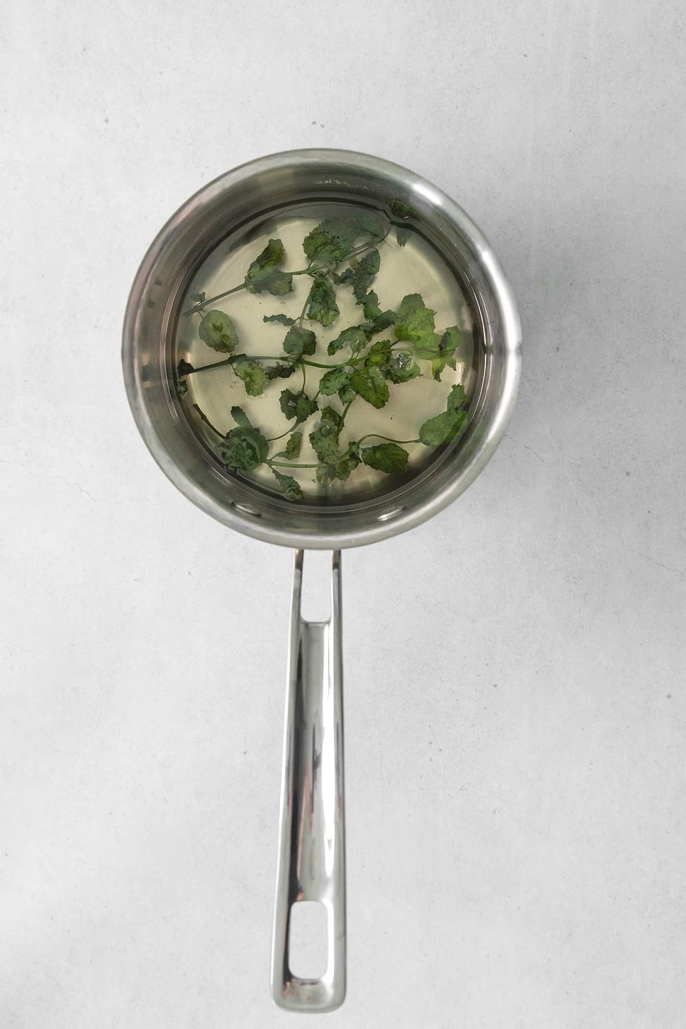 Overhead view of mint simple syrup in a saucepan