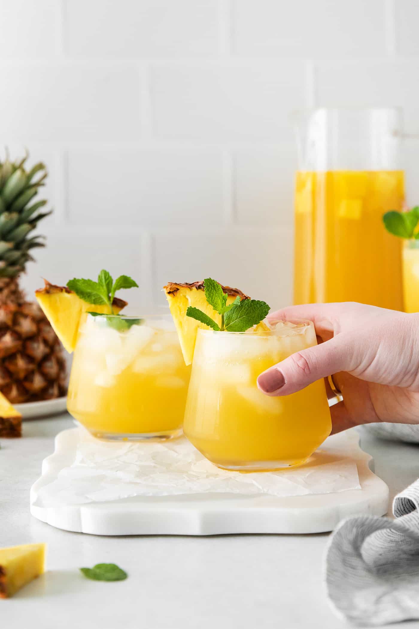 A hand grabbing a pineapple sangria
