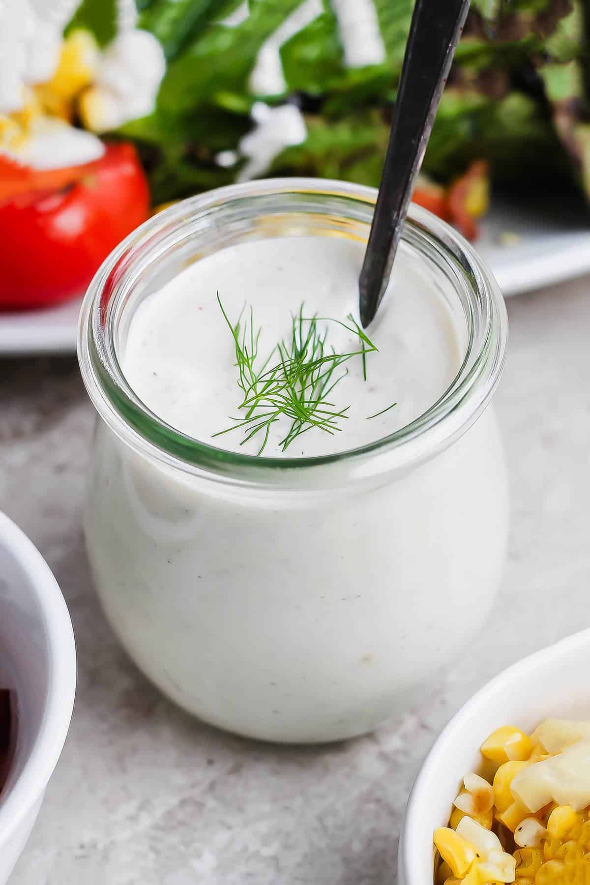 This Homemade Buttermilk Ranch Dressing recipe is fresh, creamy and tangy, with a few tweaks that really make the flavor pop. So easy too! Jar of buttermilk ranch dressing with spoon
