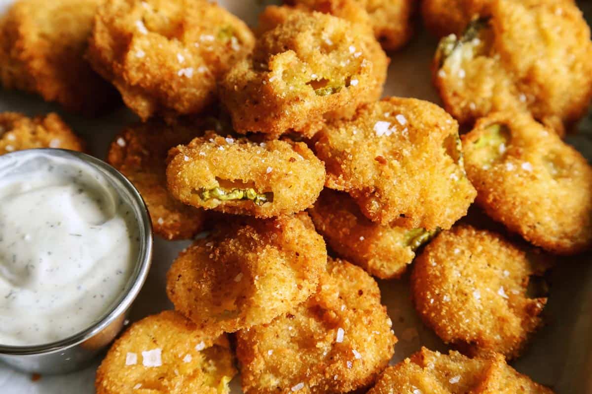Enjoy your favorite fair food at home with these easy Fried Pickles. Dill pickles are dipped in a perfectly seasoned batter and quickly fried. fried pickles on tray with ranch dip
