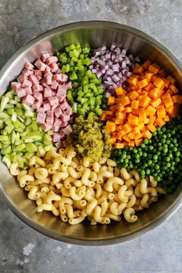Adding all of the salad ingredients to a bowl.