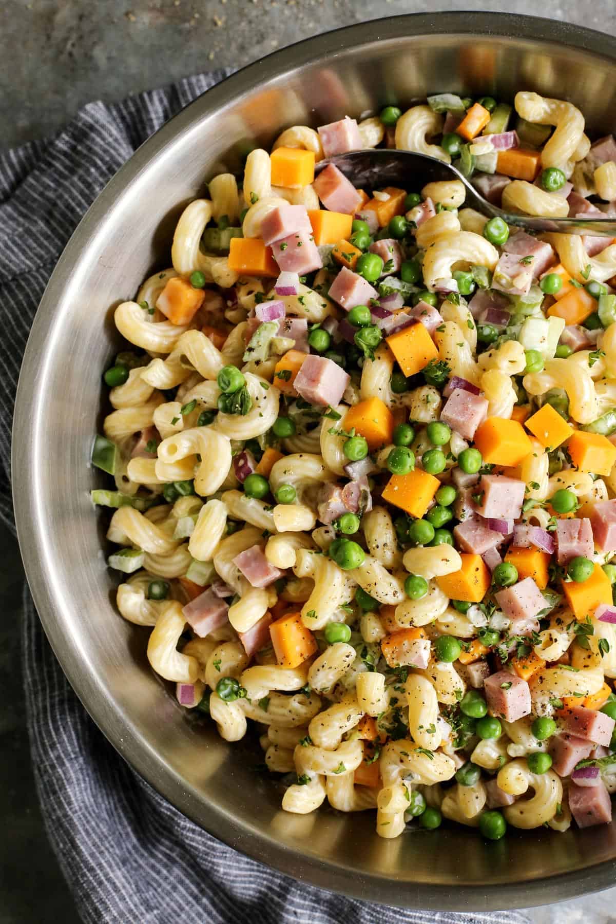 Veggie-packed macaroni salad with ham in a large bowl.