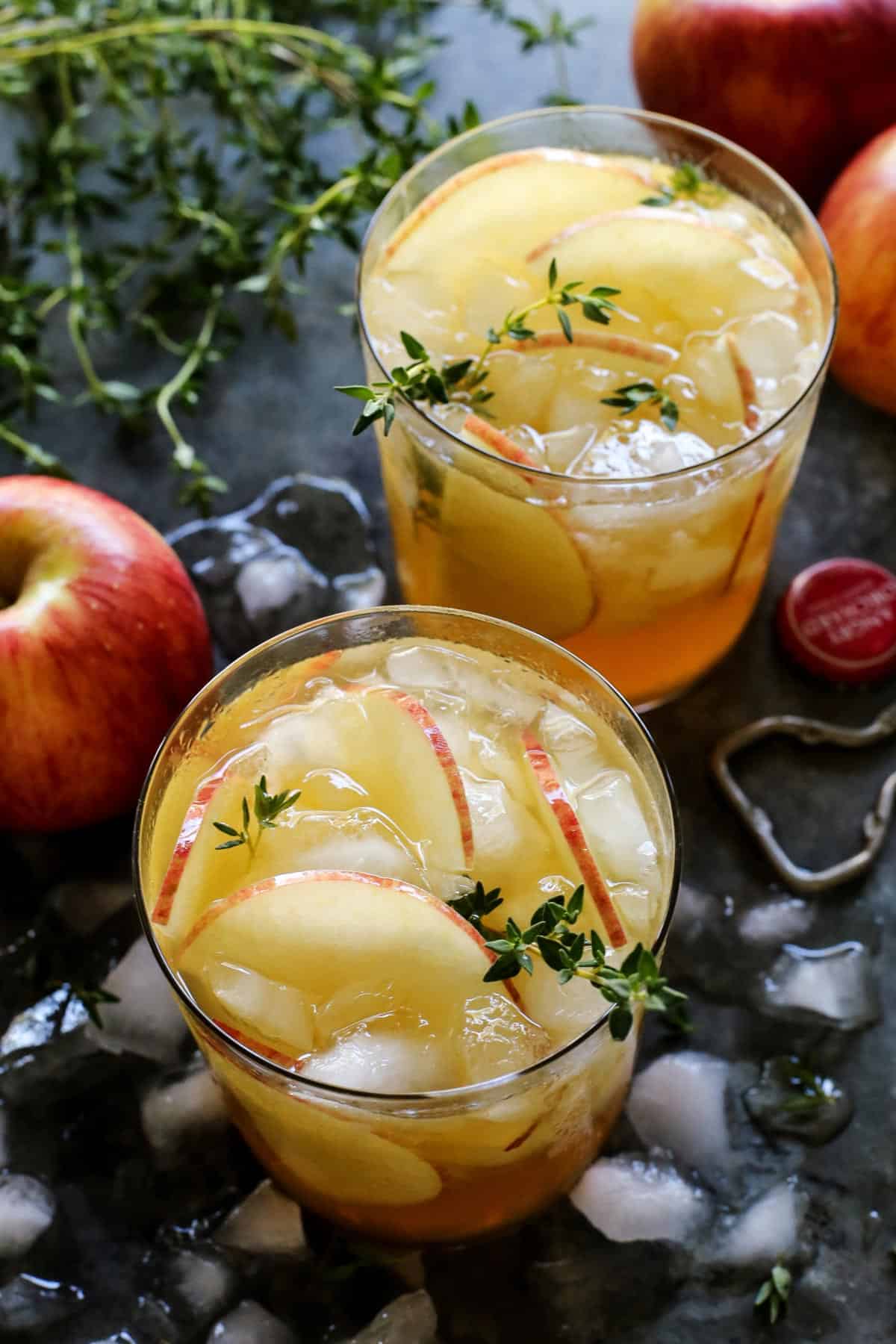 Close-up of my apple cider sangria recipe with ice and a rosemary sprig.