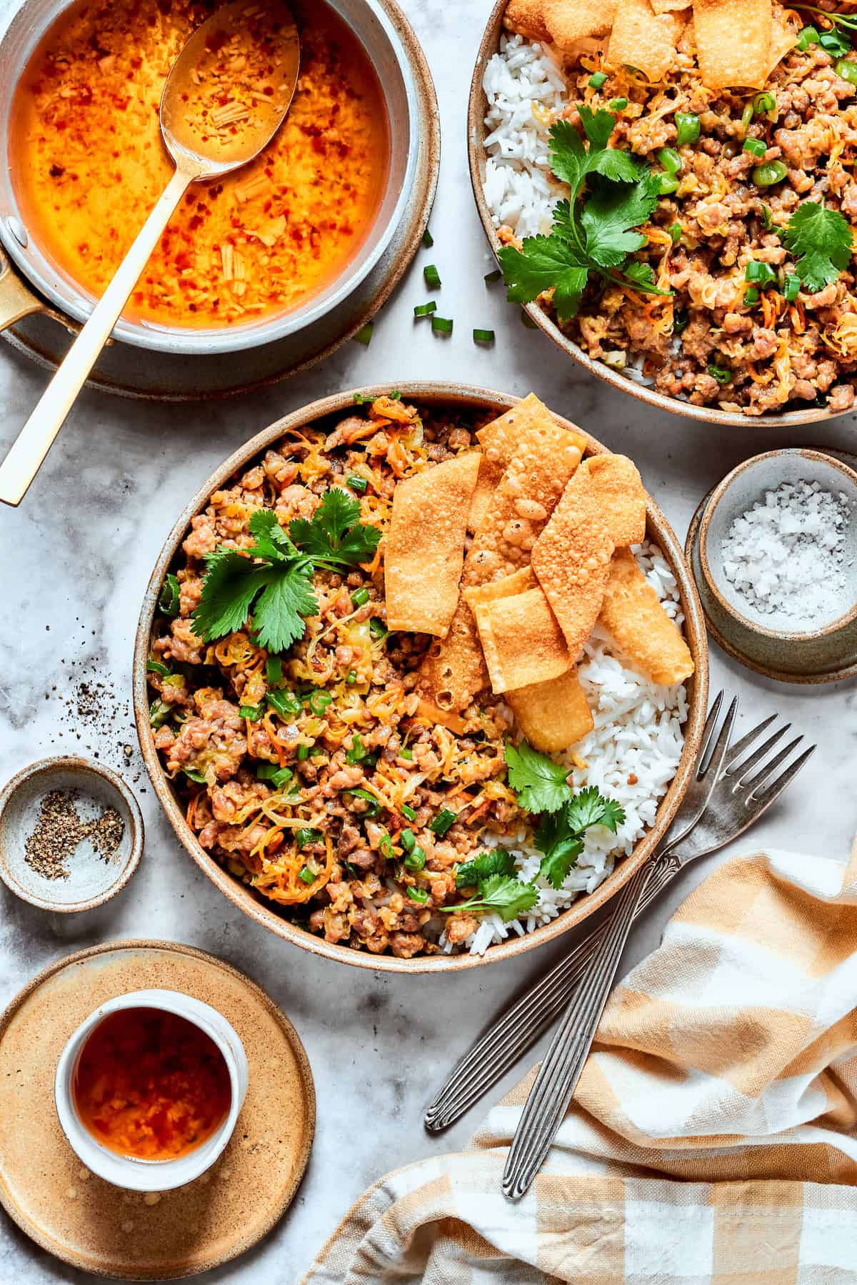 This easy Egg Roll in a Bowl recipe is loaded with ground pork, cabbage and carrots. Served with crispy wonton strips and a tasty Asian sauce! Overhead view of egg roll in a bowl with rice and wonton chips