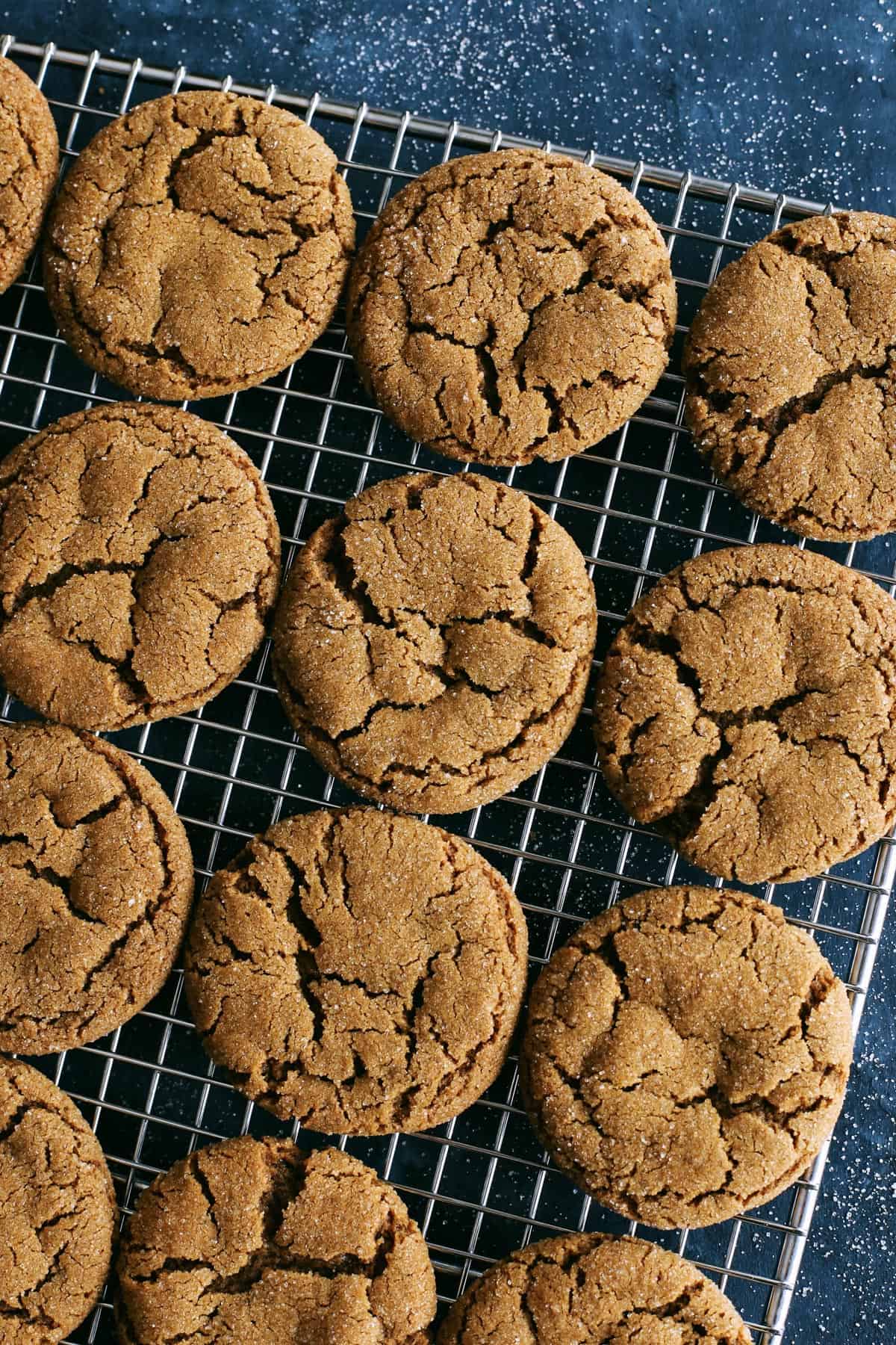 This Ginger Molasses Cookies recipe is easy to make, with no need to chill the dough, and creates perfectly soft and chewy cookies. A batch of ginger molasses cookies on a cooling rack.