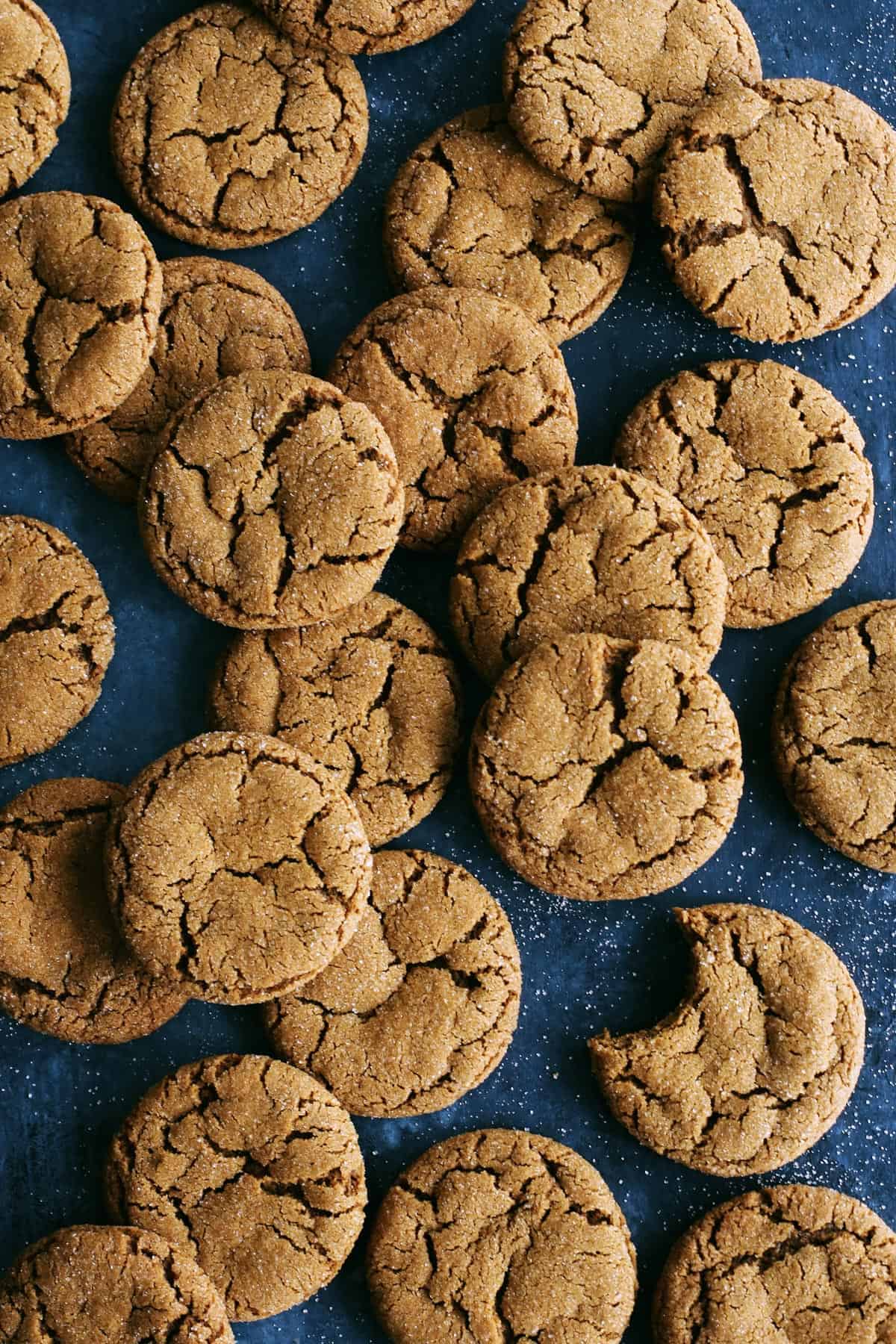 This Ginger Molasses Cookies recipe is easy to make, with no need to chill the dough, and creates perfectly soft and chewy cookies. Ginger molasses cookies on a dark background.