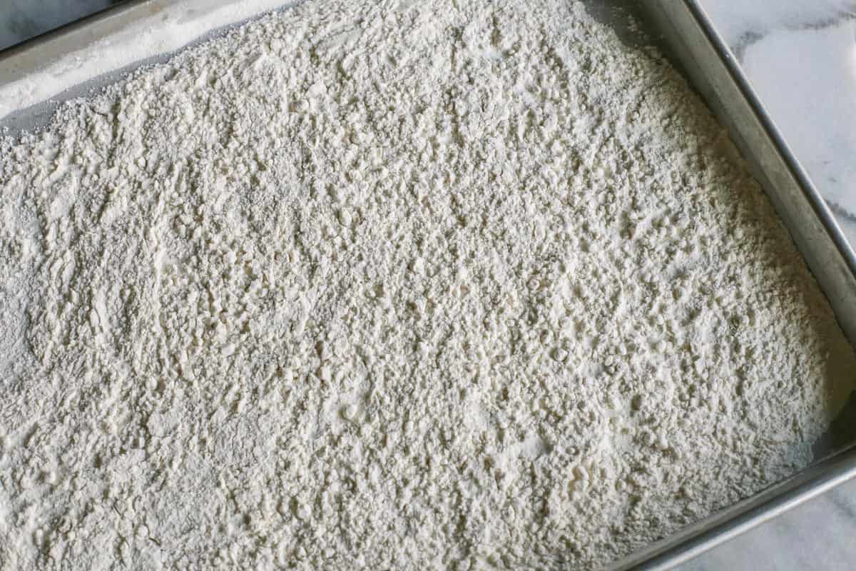 An easy edible cookie dough recipe that's egg-free and made with heat-treated flour so it's safe to eat. Refrigerate or freeze it for later! flour spread out on a large rimmed pan