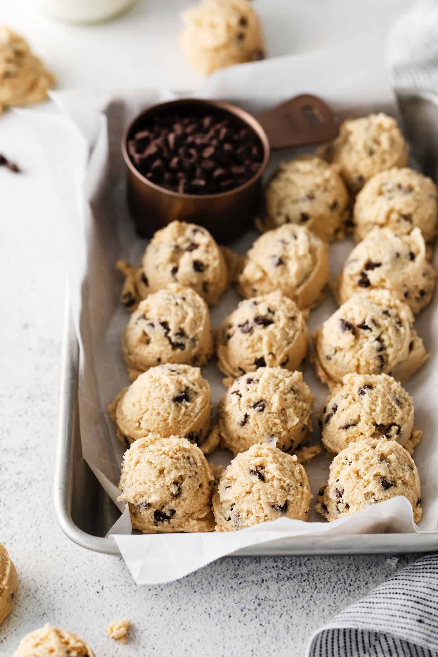 An easy edible cookie dough recipe that's egg-free and made with heat-treated flour so it's safe to eat. Refrigerate or freeze it for later! Scoops of edible chocolate chip cookie dough in a pan