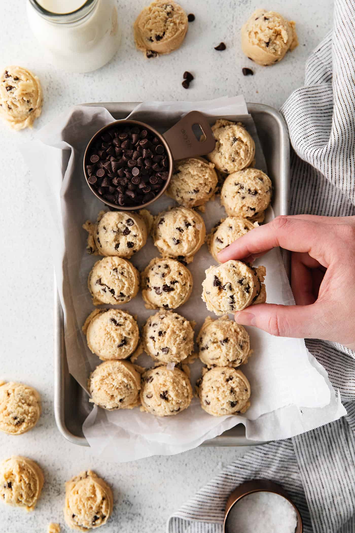An easy edible cookie dough recipe that's egg-free and made with heat-treated flour so it's safe to eat. Refrigerate or freeze it for later! A hand reaching for a scoop of edible cookie dough