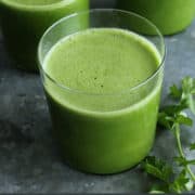 pinterest image of three glasses of green juice, plus fresh spinach, cucumbers, celery, green pepper, and parsley
