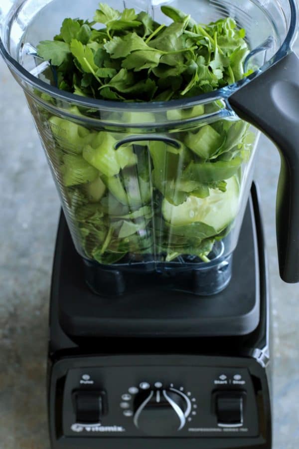 Green Juice is an easy blender recipe that whirls together spinach, parsley, cucumber, celery, green bell pepper, and orange juice. fresh green ingredients in blender pitcher