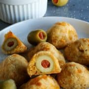 olives surrounded by cheesy dough, on a white plate