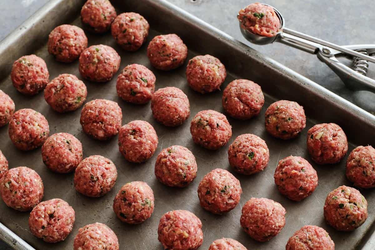 Raw homemade meatballs on a pan