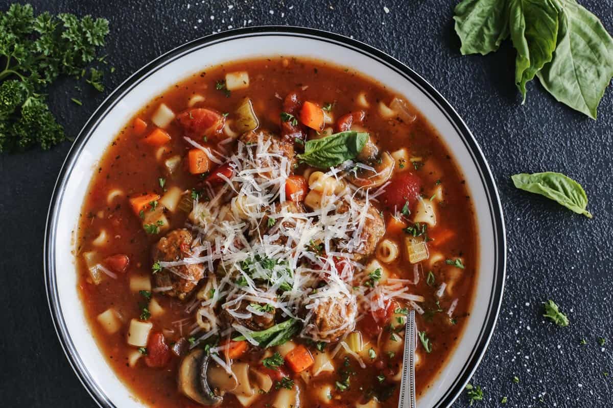 Italian meatball soup in a bowl with cheese 