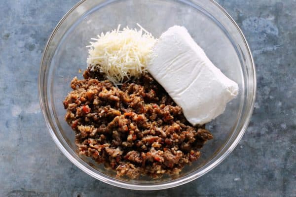 With Italian sausage, cream cheese, Parmesan, and mozzarella, these easy stuffed jalapeños are extra cheesy with the perfect amount of heat! browned Italian sausage, cream cheese, and shredded Parmesan cheese in a bowl