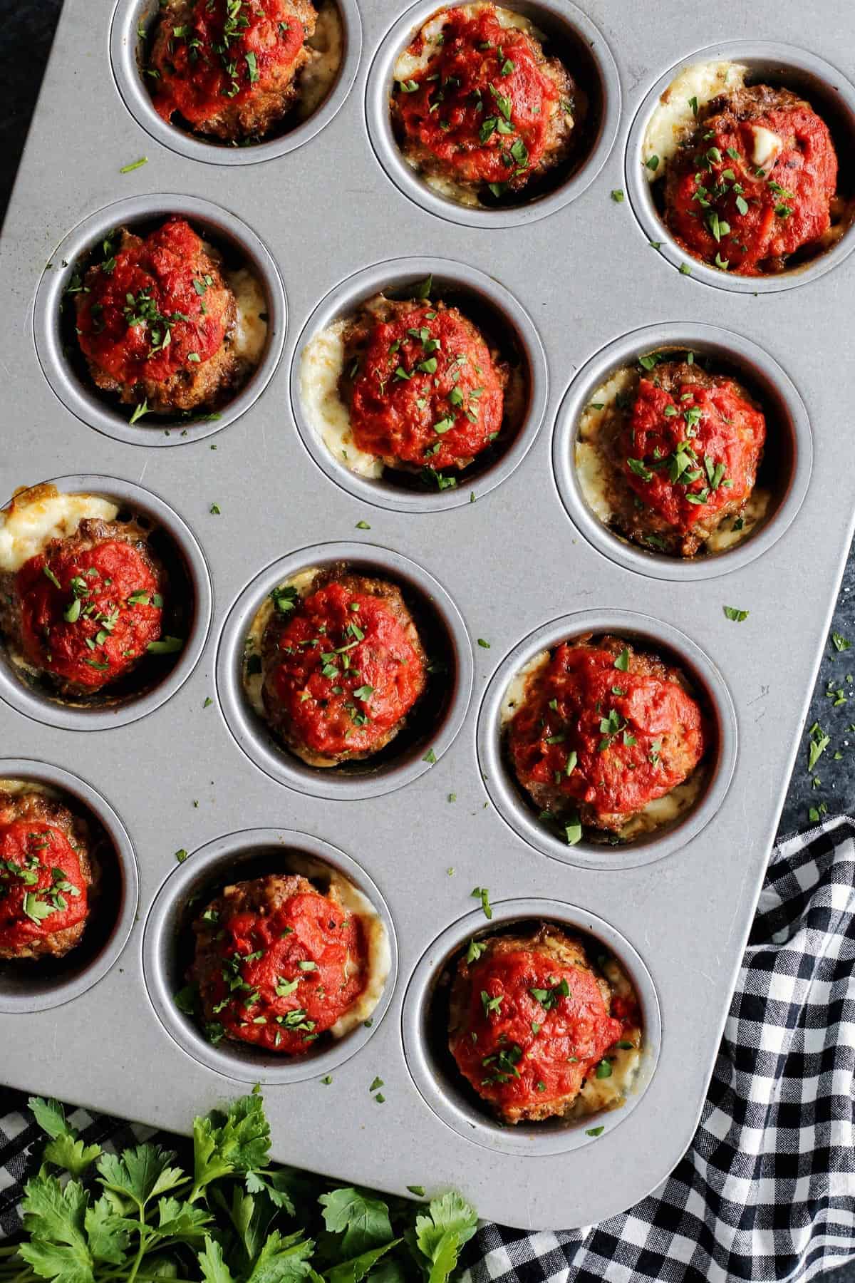 Italian Meatloaf Muffins turns your favorite meatloaf into muffins with gooey mozzarella cheese centers and savory herbs. Meatloaf muffins with cheese in a muffin pan