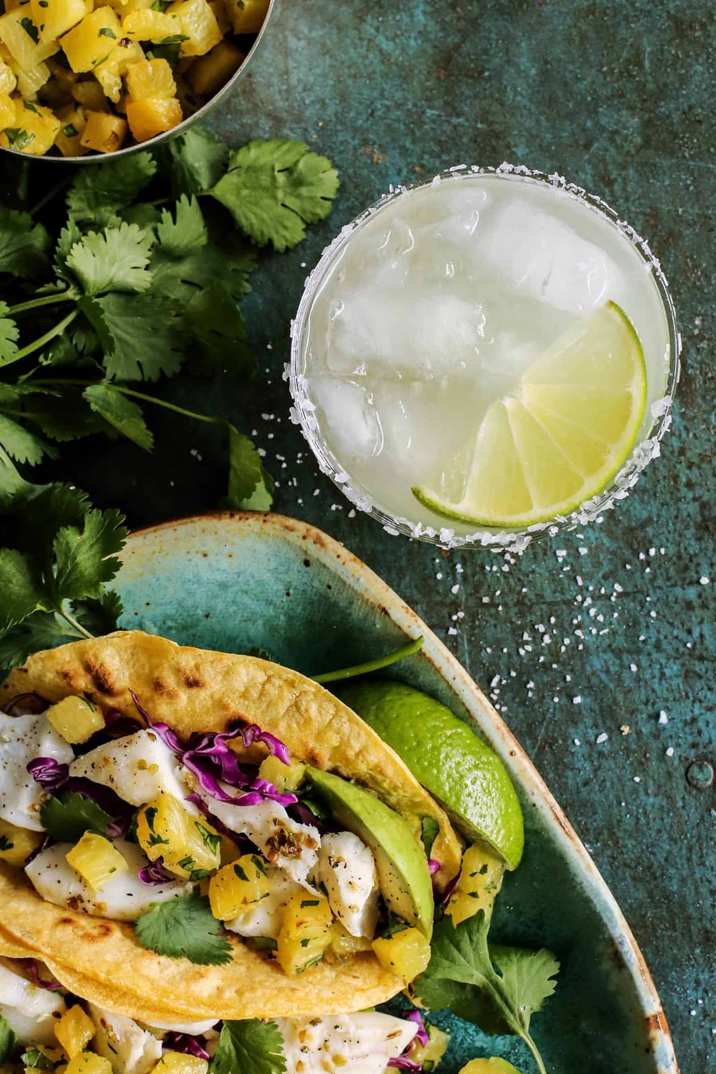 One of the best Fish Tacos Recipes layers caramelized pineapple with lime-spiked white fish, plus creamy avocado and crunchy pickled onions. a margarita with fish tacos
