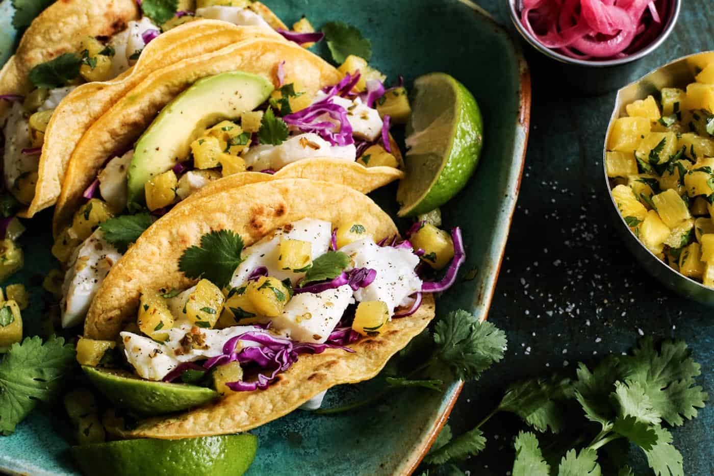 One of the best Fish Tacos Recipes layers caramelized pineapple with lime-spiked white fish, plus creamy avocado and crunchy pickled onions.